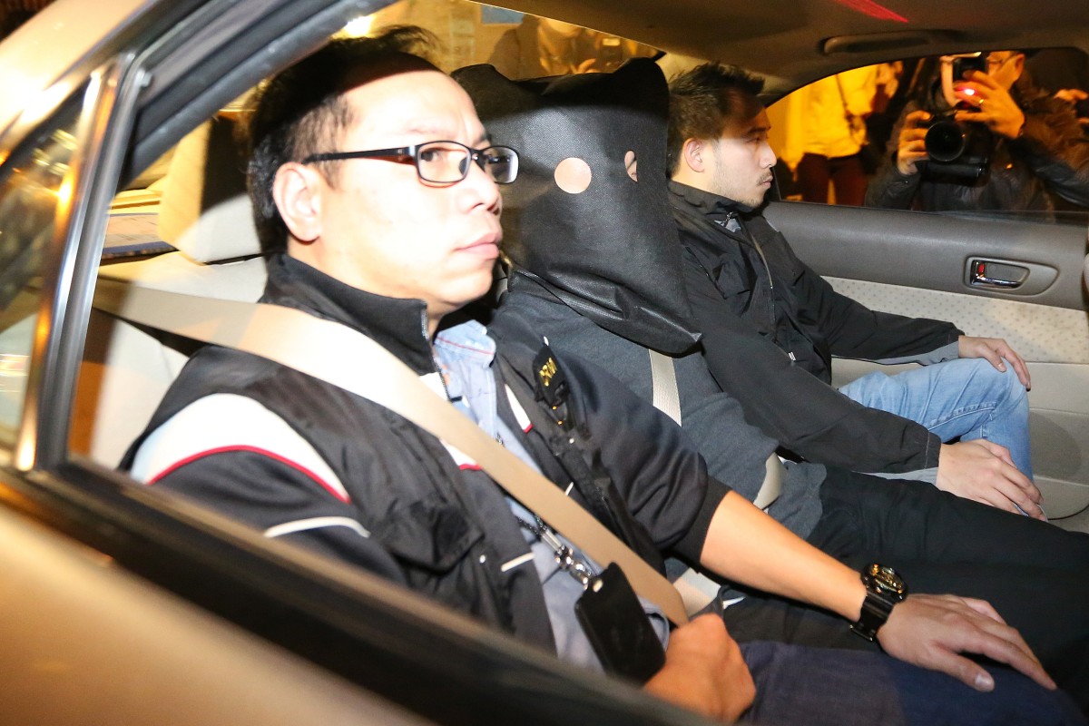 Police officers arrest a man (centre with hood) suspected of the murder.