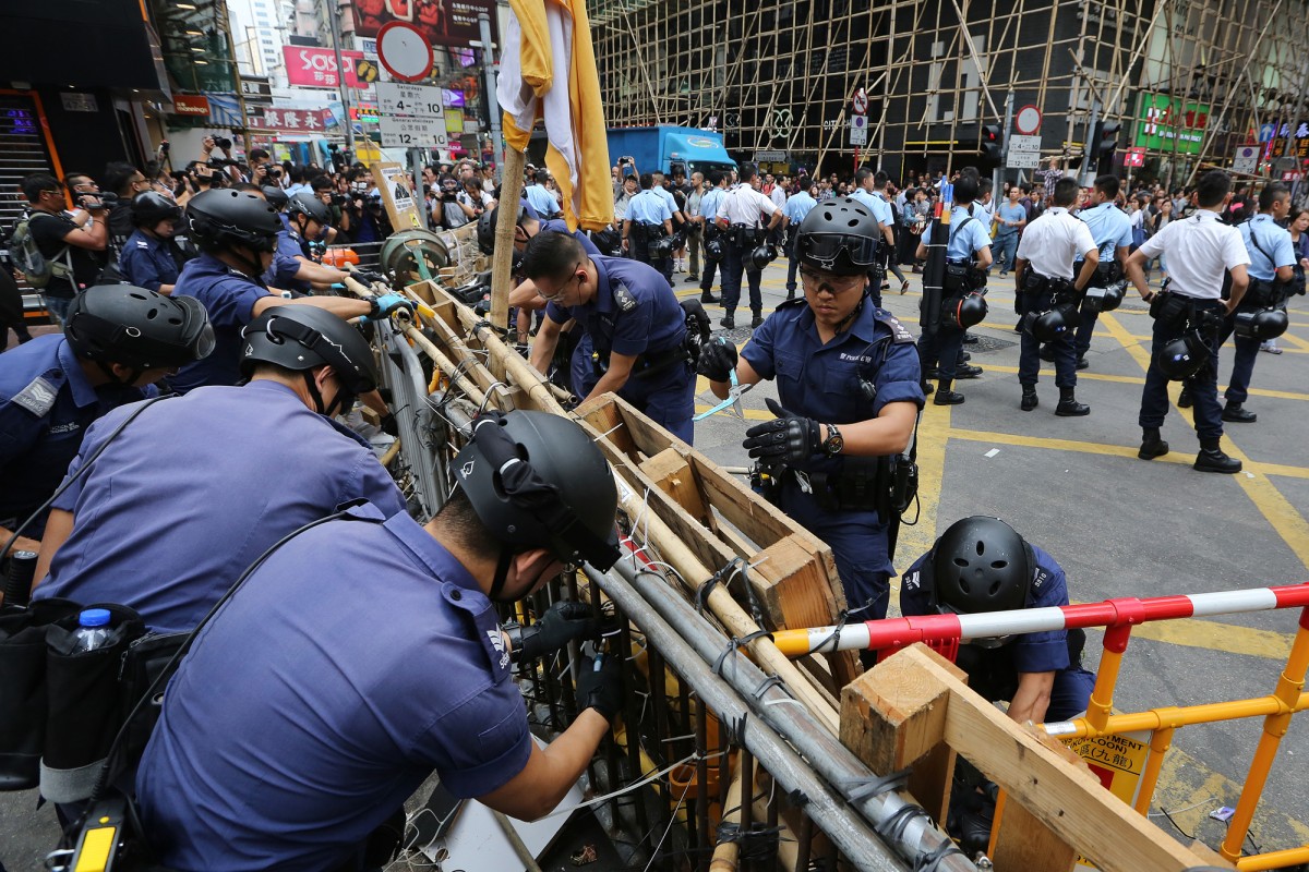 Police officers remove a barricade in Mong Kok