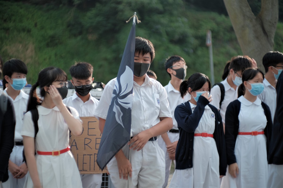 About 80 students and a handful of alumni gather at the parking area within Shau Kei Wan Government Secondary School's campus before class on Tuesday morning.