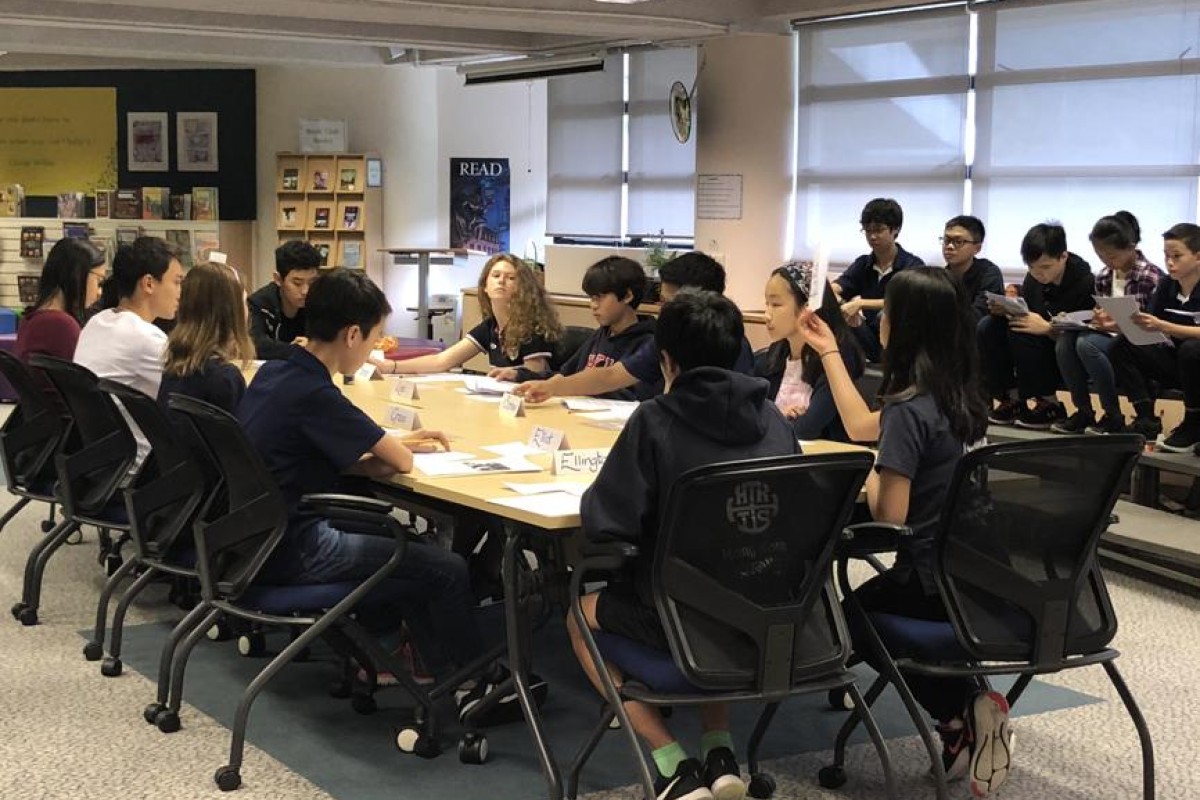 Eighth graders speaking passionately in a Socratic Seminar about modern slavery.