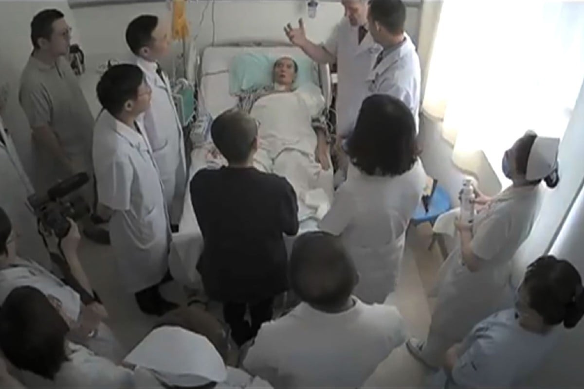 Undated video grab shows Liu Xiaobo (C) surrounded by doctors and his wife Liu Xia (in black).