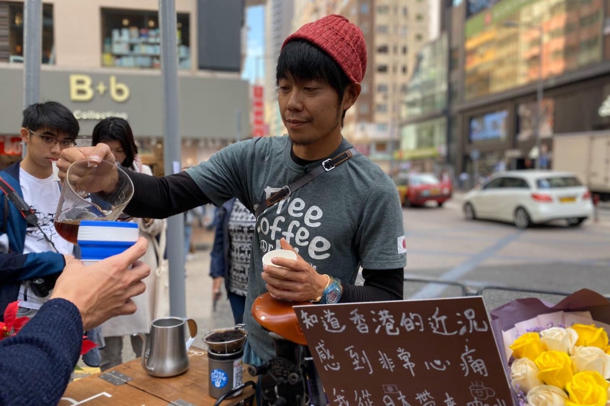 Masanori Nishikawa stood on O'Brien Road in Wan Chai, giving out free coffee to Hongkongers.