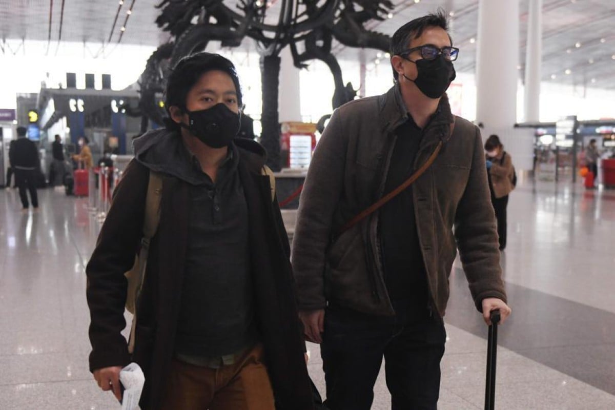 Wall Street Journal reporters Josh Chin (R) and Philip Wen walk through Beijing Capital Airport before their departure.