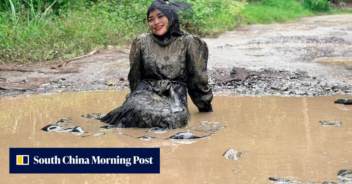Indonesian mother who fell off motorbike sits in muddy pothole-filled roads to protest official inaction Indonesian mother who fell off motorbike sits in muddy pothole-filled roads to protest official inaction
