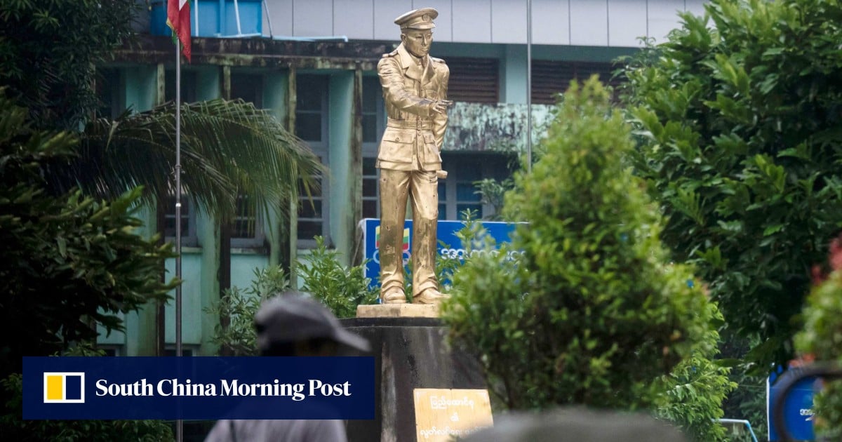 Một phụ nữ đi qua tượng của anh hùng độc lập Myanmar Aung San tại công viên Thu Mingalar ở Yangon vào ngày 16 tháng 7 (Ảnh: AFP)