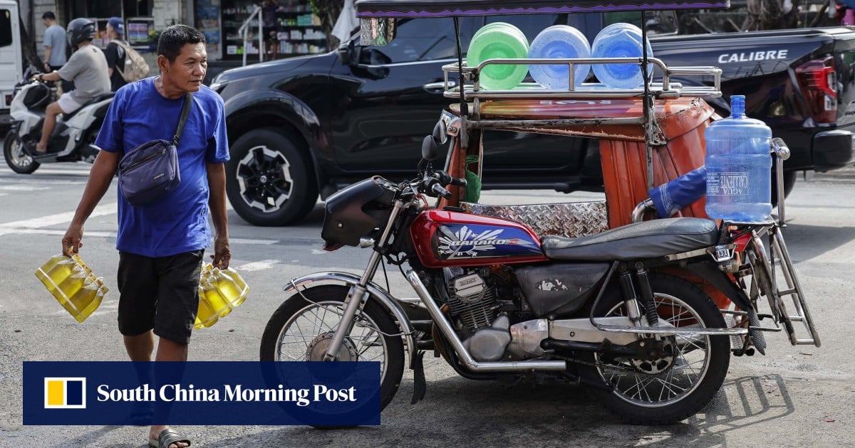 Một người bán hàng mang các chai dầu ăn đi bán tại chợ ở Quezon City, Philippines, ngày 7 tháng 7 (Ảnh: EPA)