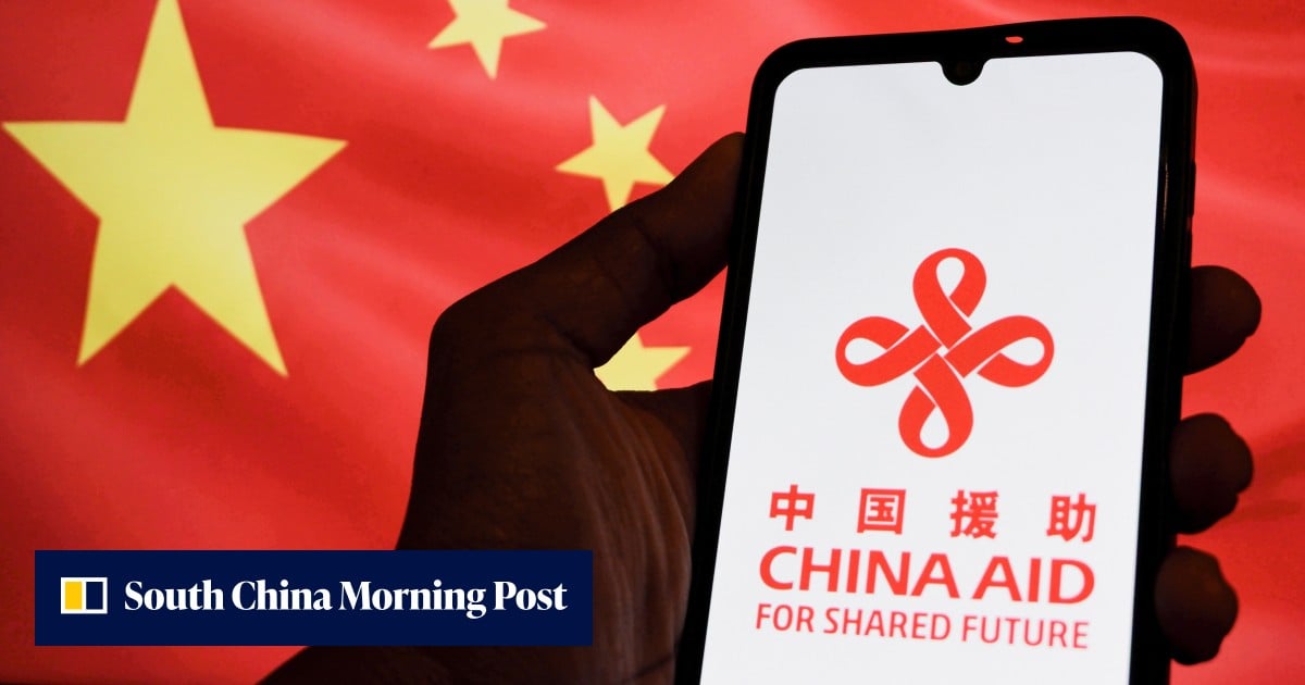 A hand holding a smartphone with a logo against the Chinese flag.