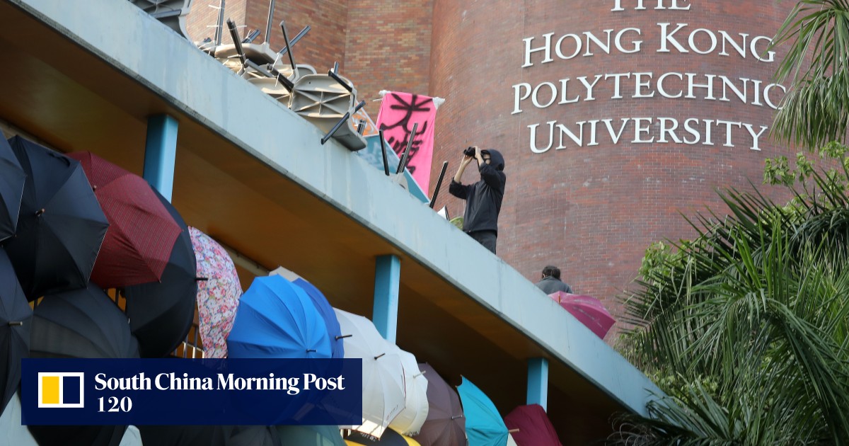 A person is taking pictures of a protest in front of Hong Kong Polytechnic University.