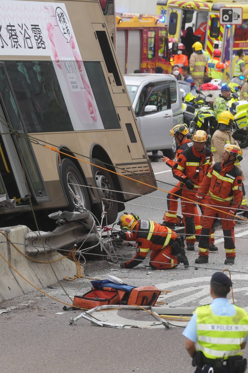 Double decker bus in Hong Kong crashes into road barrier and tilts to