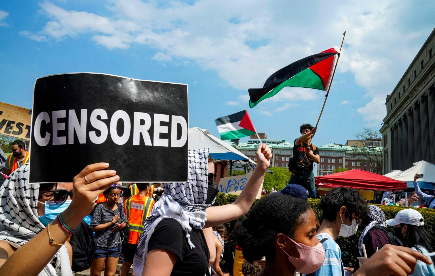 Pro-Palestinian students and activists hold signs and wave a Palestinian flag in Columbia University on April 29, 2024. Photo: AFP