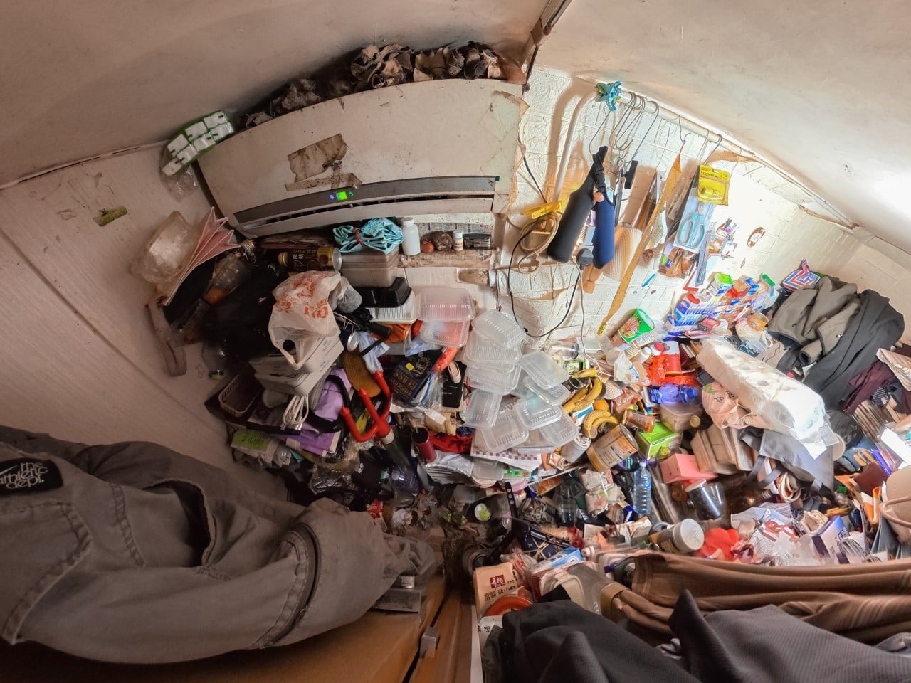 An elderly tenant surnamed Au in his “coffin home”, surrounded by his belongings. Photo: Eugene Lee