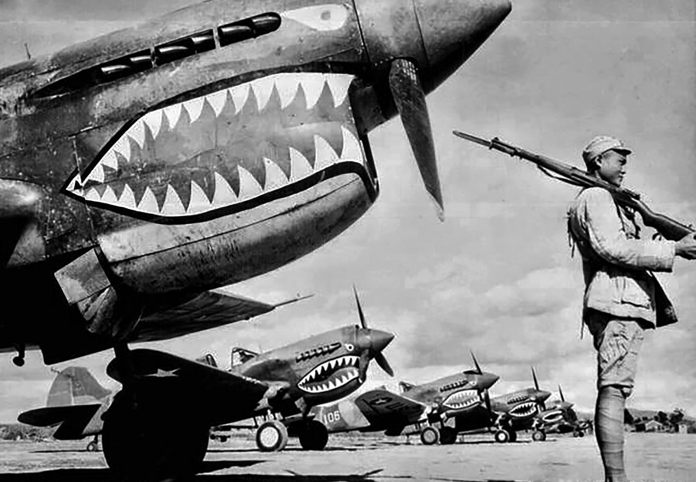 Guarded by a Chinese soldier, a squadron of Curtiss P-40 fighter planes, decorated with the typical shark face of the famed Flying Tigers, is lined up at an unknown airbase in China in 1943. Photo: Handout