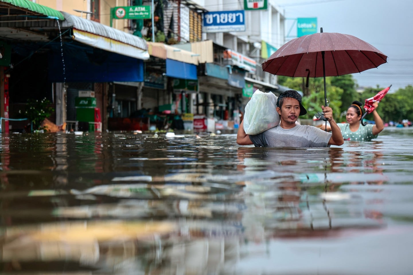 Residents wade through a flooded area during heavy rain in Bangkok, Thailand, on September 27. Photo: Reuters