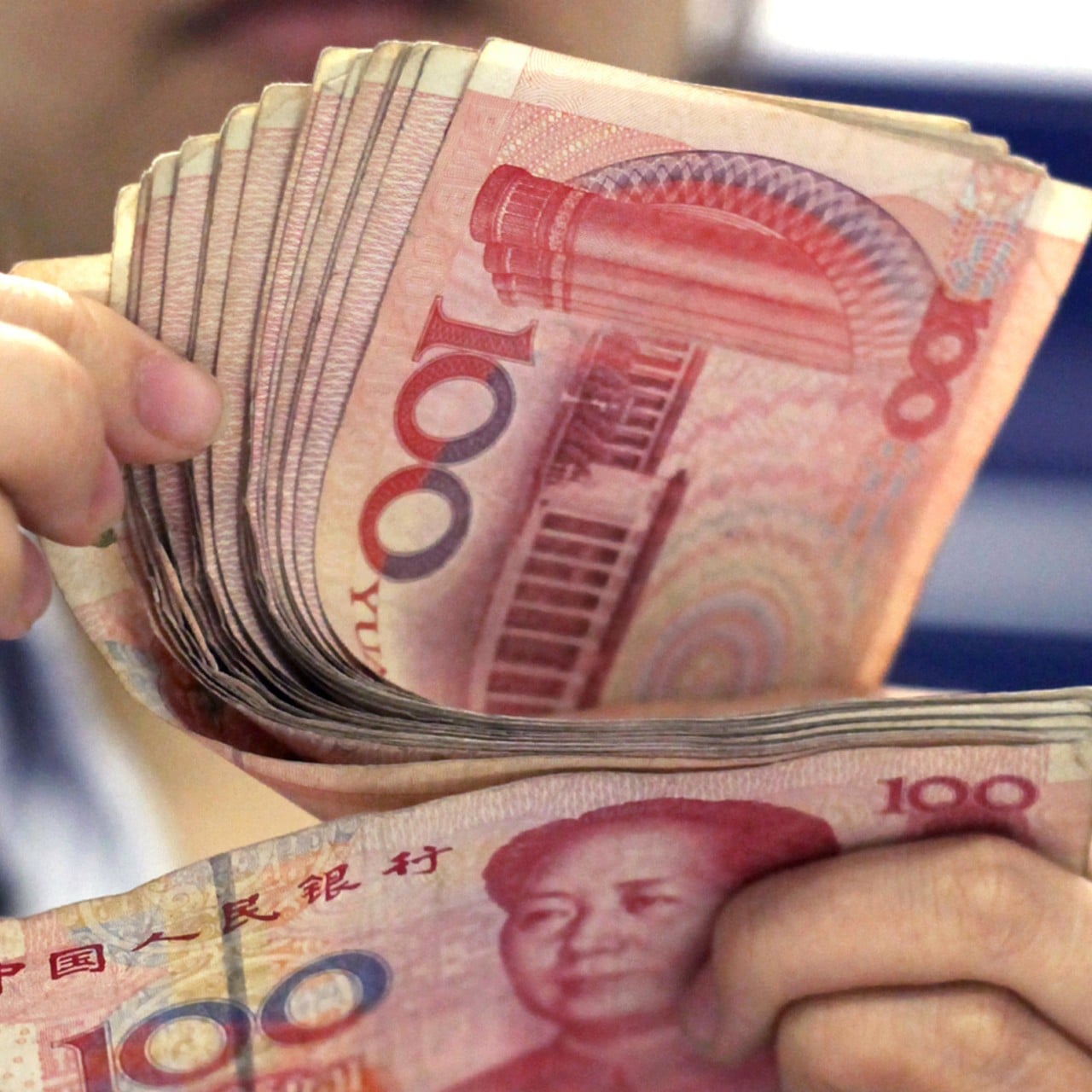 A bank clerk counts Chinese 100 yuan notes in Shanghai. Photo: AP