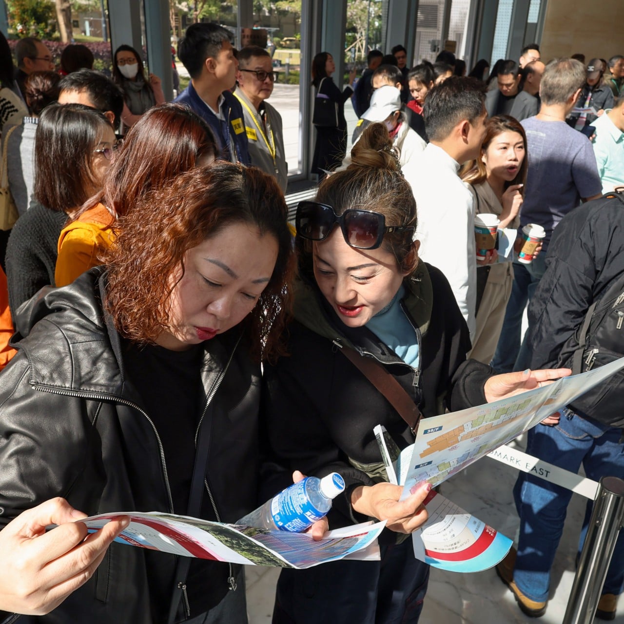 Prospective buyers pore over brochures on the first day of the sale of Cloudview, the new development in Sheung Shui by Wing Tai Properties, on March 14, 2026. Photo: Dickson Lee
