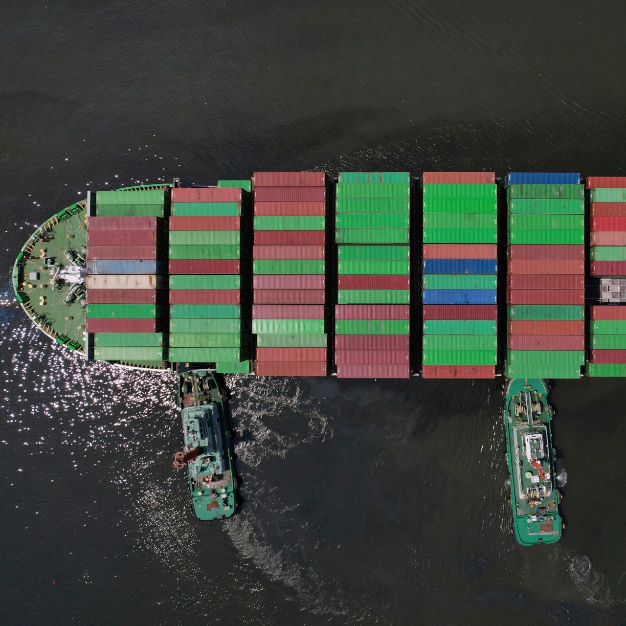 Tugboats assist a container ship as it prepares to dock at the Manila International Container Terminal on April 8. Photo: AP 