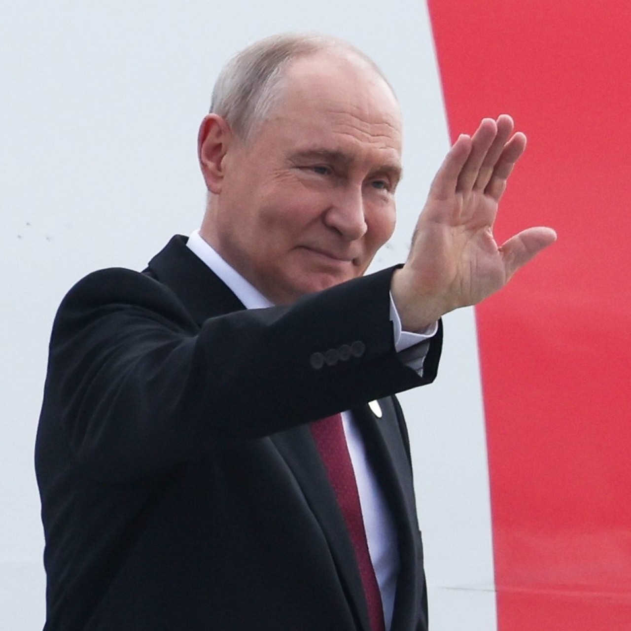 Russian President Vladimir Putin waves while boarding a plane upon his departure from India on September 13. Photo: Kremlin/Sputnik/EPA