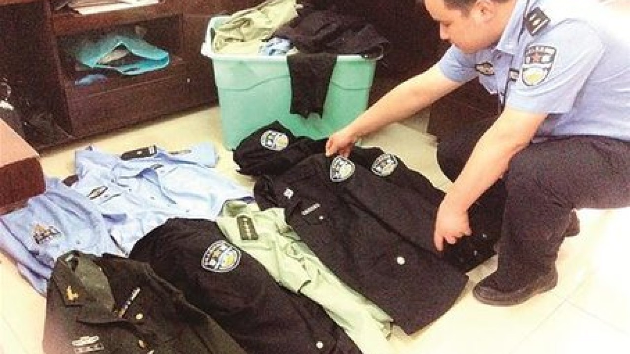 FILE--A Chinese police officer and workers confiscate fake Louis