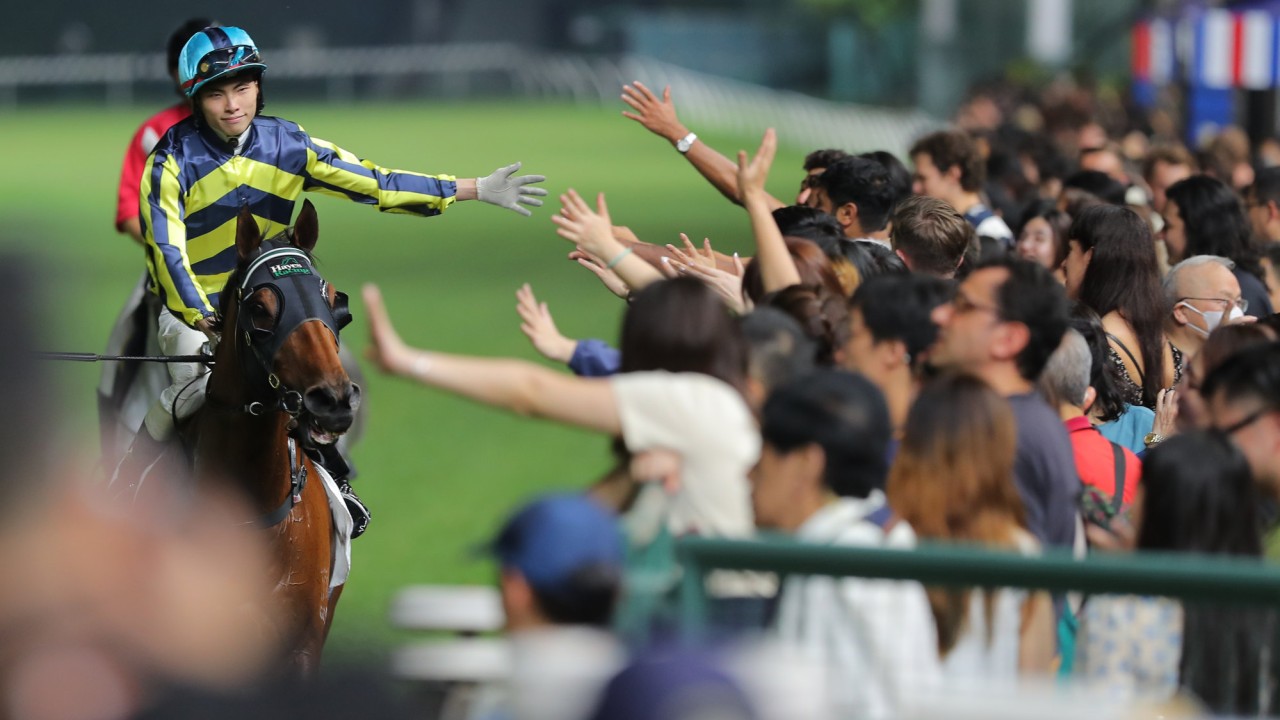 Ellis Wong high-fives the Happy Valley crowd after winning on Dragon Delight.