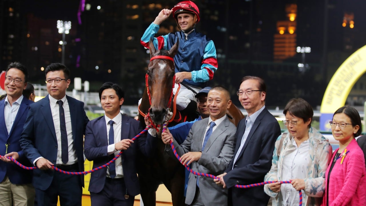 Lyle Hewitson celebrates with connections after piloting Winning Champion to victory at the Happy Valley season finale.