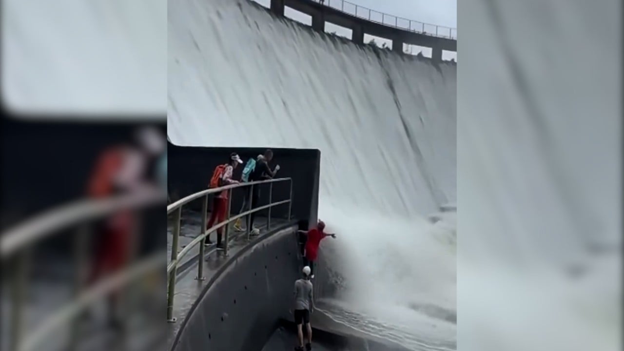 Hikers pose for photos as Hong Kong dam floodgate opens