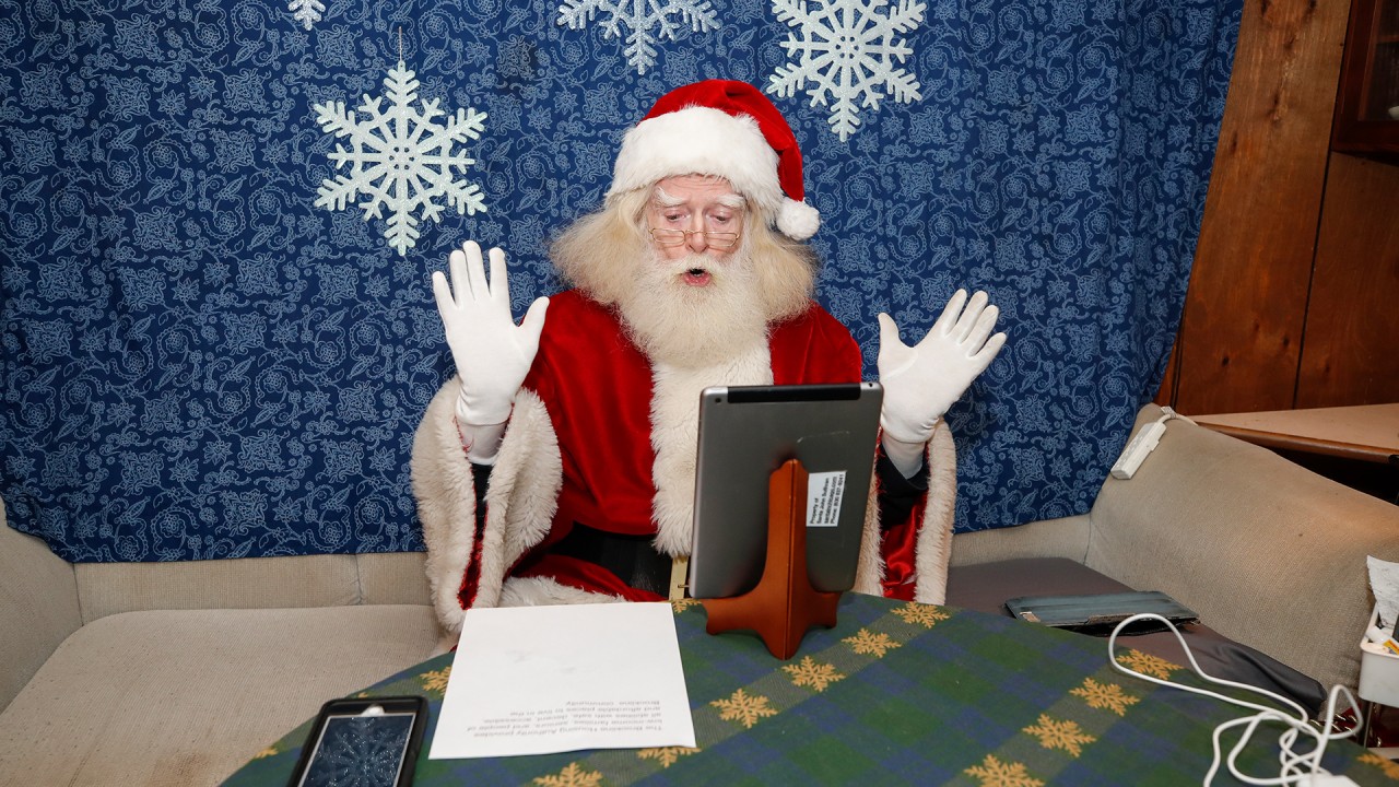 Santa Claus works from home to greet children in virtual meetings during pandemic