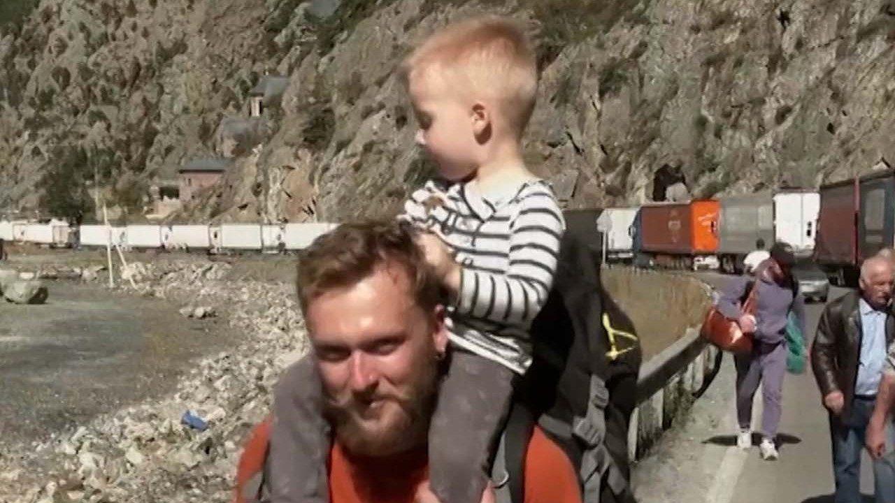 Flocks of Russians flee to avoid draft orders, while those who stay receive blessings